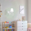 Biały kinkiet z abażurem i ozdobnym kryształkiem w pokoju dziecięcym